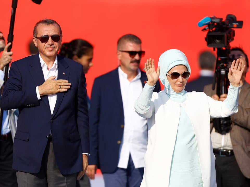 Das Ehepaar Erdogan, umringt von Sicherheitskräften und Medien.