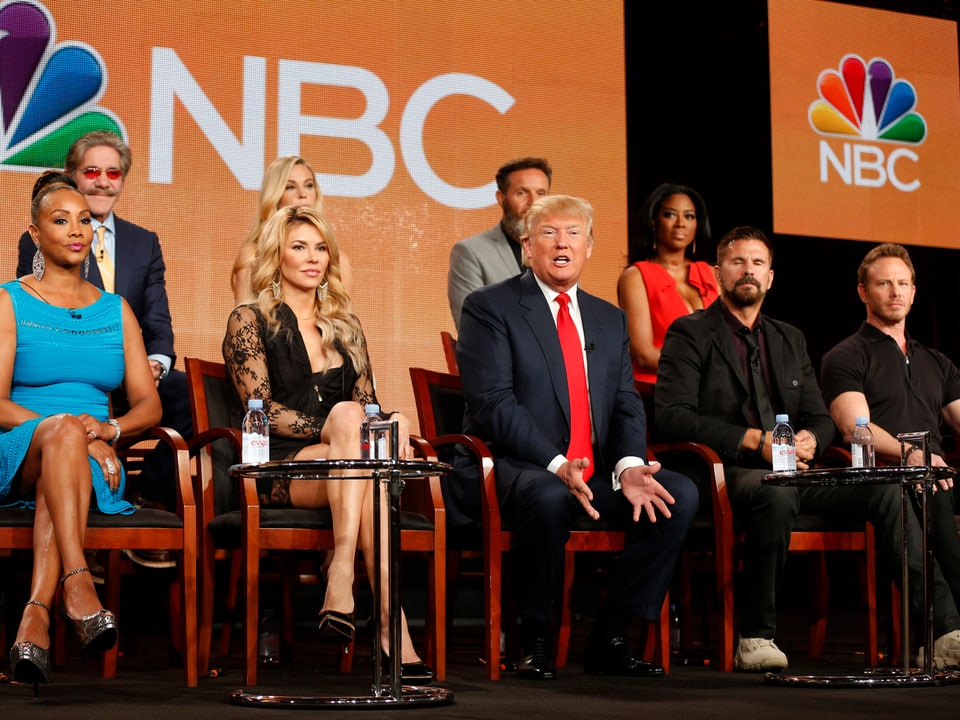 Trump sitzt im TV-Studio inmitten von Kandidaten seiner Show "the Apprentice".