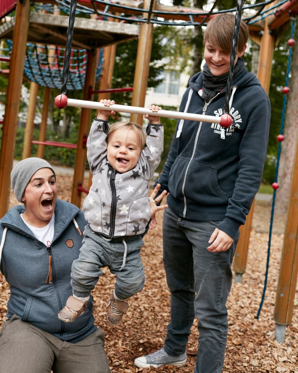 Zwei Fraue und ein Baby auf dem Spielplatz.