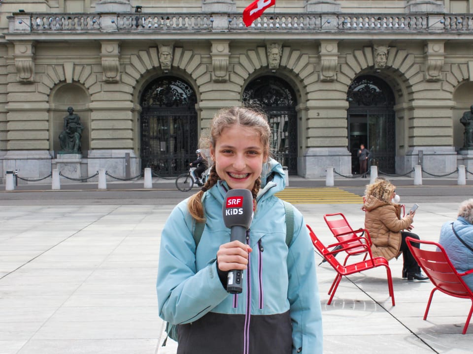 Mädchen mit Mikrophon steht vor dem Bundeshaus