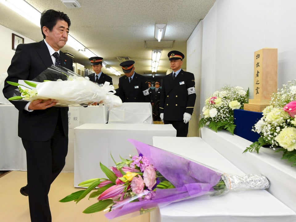 Der japanische Premier Schinzo Abe legt Blumen nieder für die Opfer des Anschlags. 