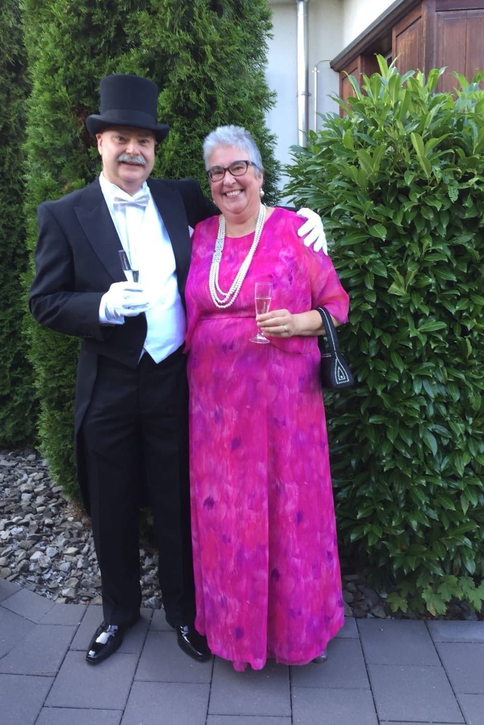 Mann mit Frack, Frau im rosaroten Kleid mit Perlenkette.