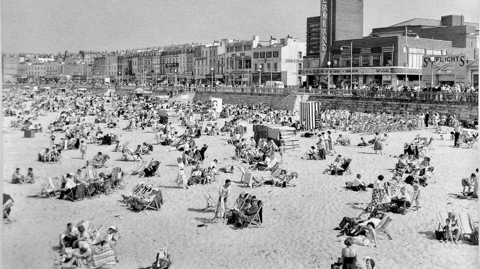 Historic black and white photo with many sunbathers.