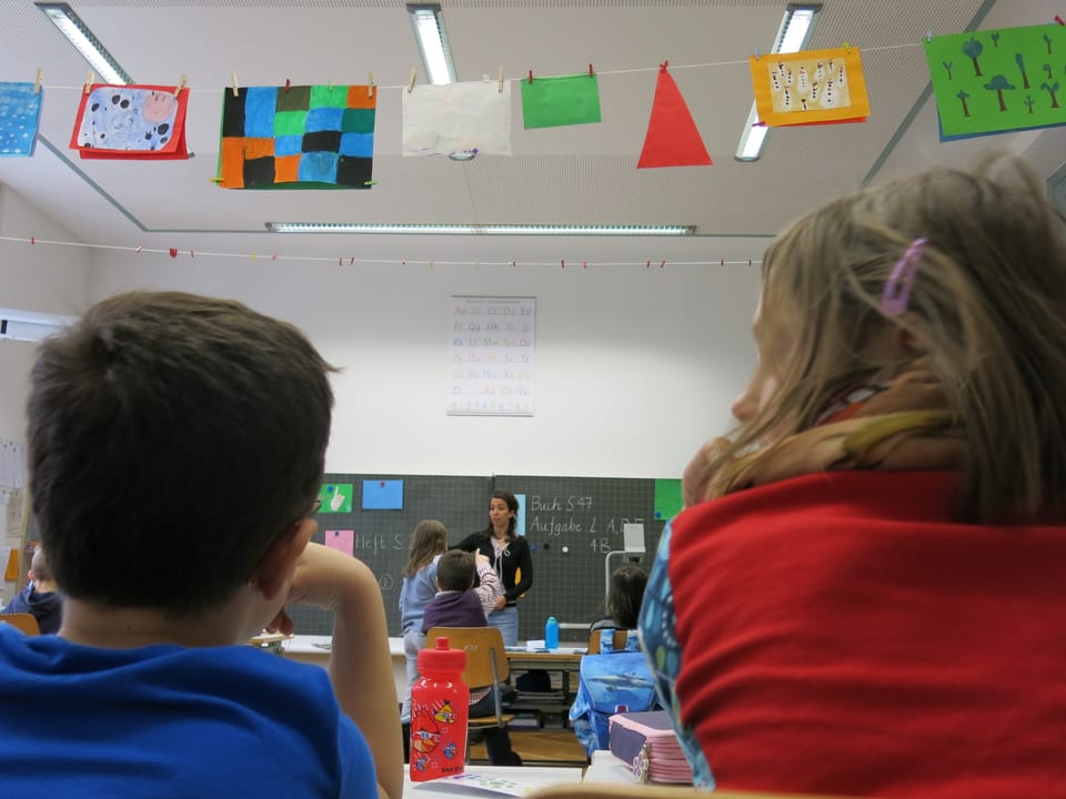 Deutschsprachige und französischsprachige Kinder sitzen nebeneinander in der gleichen Klasse. 