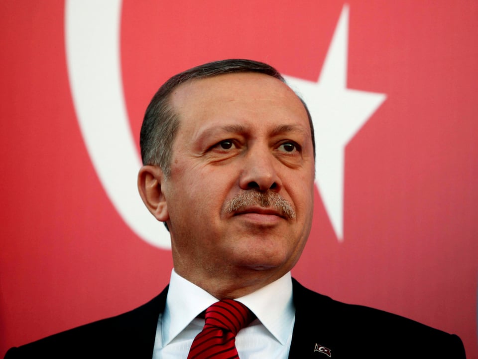 Ein Porträt von Erdogan vor der türkischen Flagge.