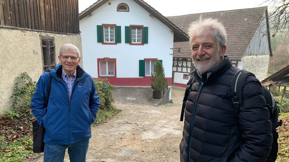 Zwei Männer vor Haus.