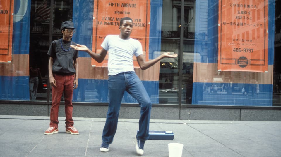 Zwei junge Männer auf der Strasse; einer tanzt