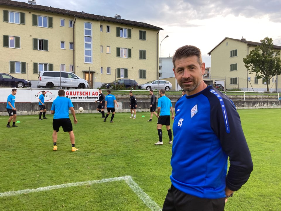 Trainer Olaf Sager steht vor seiner Mannschaft, die gerade trainiert.