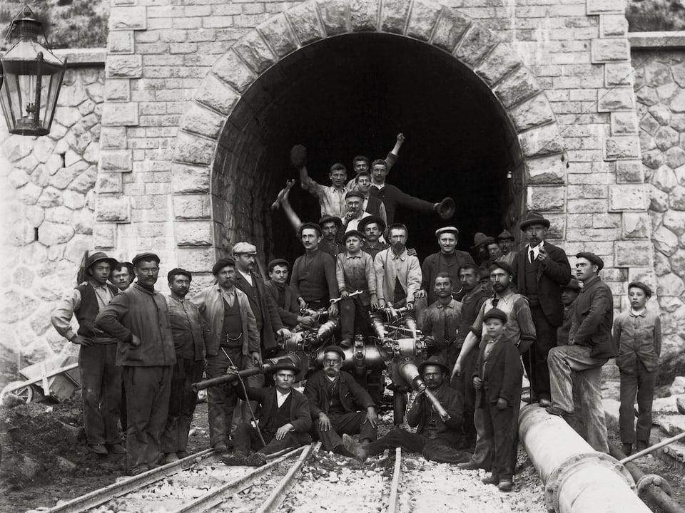 Bauarbeiter stehen stolz vor dem fertig gestellten Albulatunnel am Südportal in Spinas im Jahr 1902.