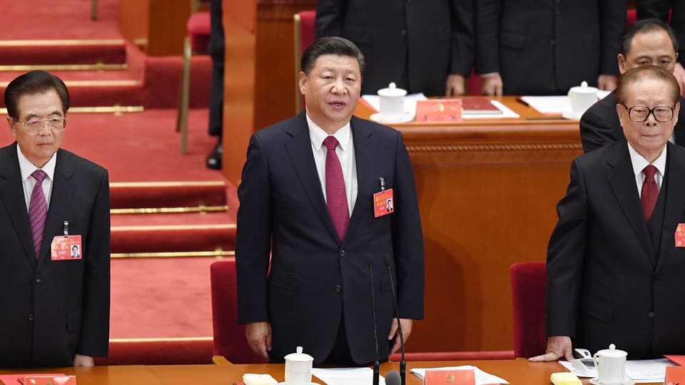 Drei ältere chinesische Männer - Hu, Xi, Jiang - stehen in Anzügen in einer Reihe.