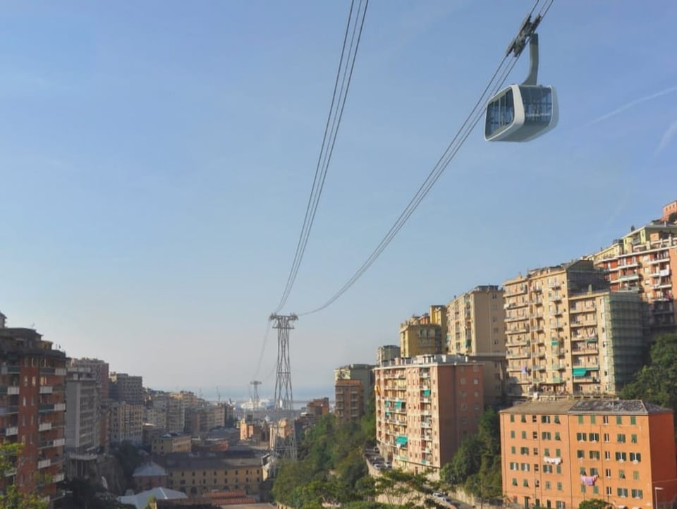 Project image: Cable car poles and cable car passing in the middle of a residential area.