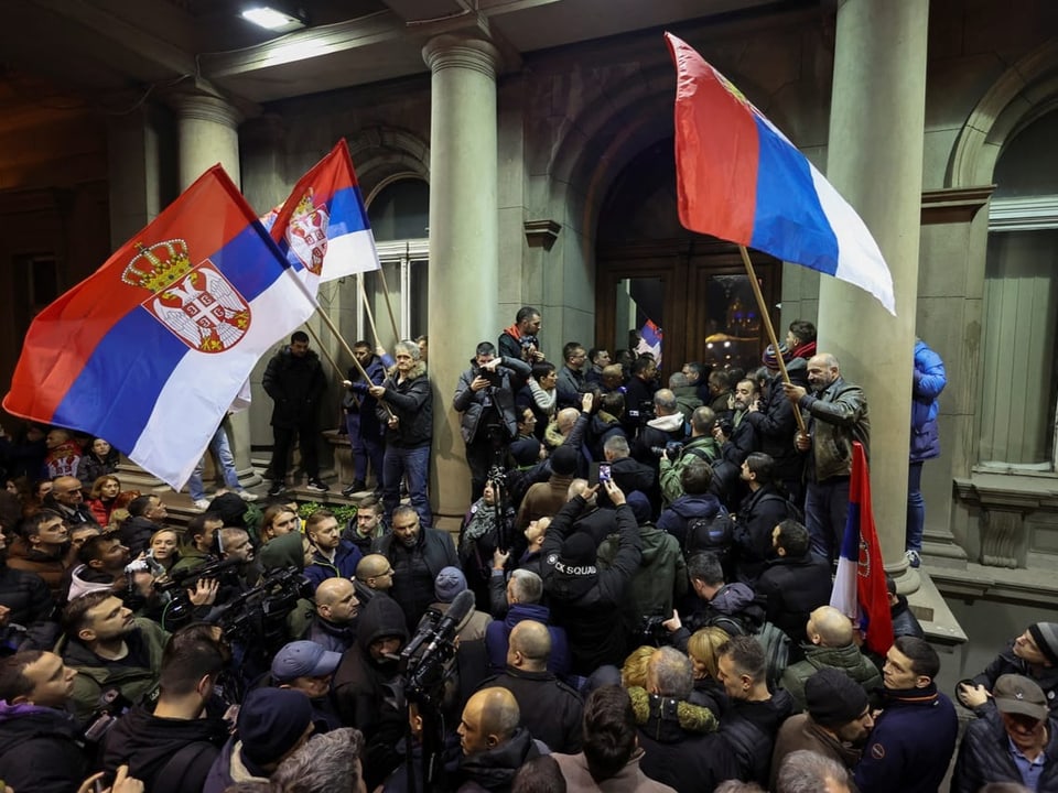 Menschen protestieren mit Serbien-Fahnen in Belgrad vor dem Rathaus.