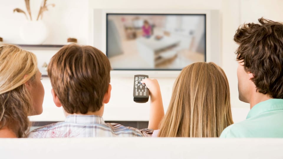 Eine Familie auf dem Sofa am Fernsehen