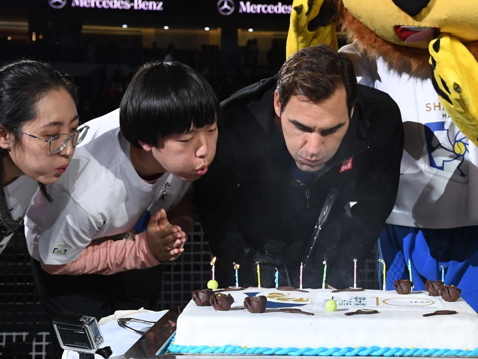 Roger Federer pustet die Kuchenkerzen aus.