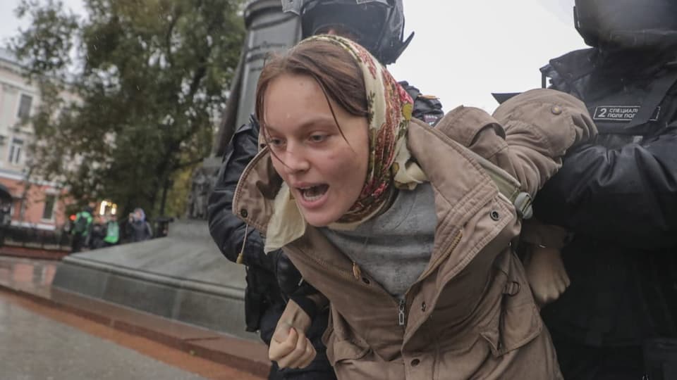 Russian police officers escort a woman protesting a partial mobilization in Moscow (September 24).