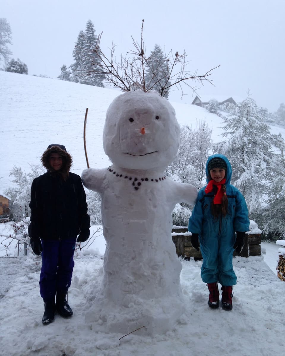 Ein Schneemann und zwei Kinder.