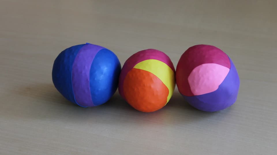 Drei Jonglierbälle auf dem Tisch in verschiedenen Farben. 