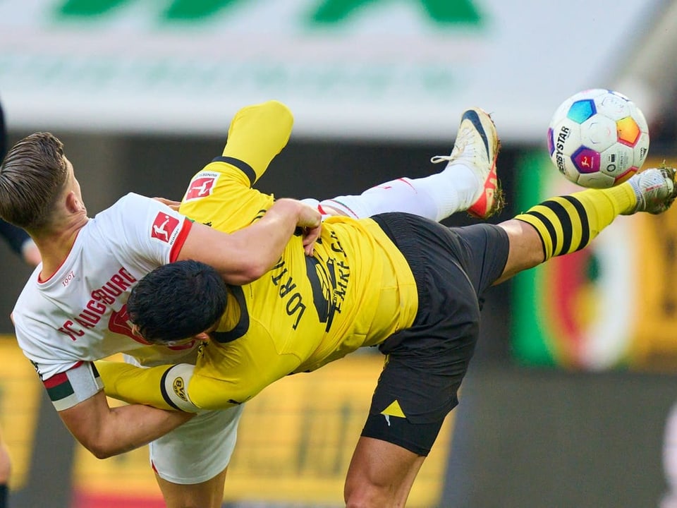 Augsburgs Ermedin Demirovic und Dortmunds Emre Can scheint der Ball in dieser Szene nicht sonderlich zu interessieren.