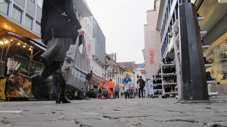 Eine Frau läuft mit einer Einkaufstasche durch die Einkaufspassage in Aarau.