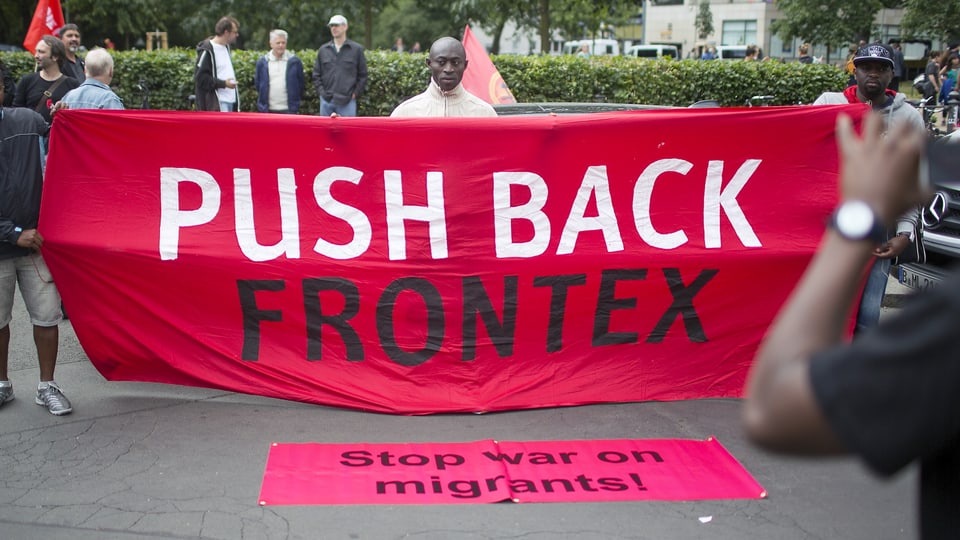 Aktivisten halten am Weltflüchtlingstag Transparente mit der Aufschrift "Weiche zurück, Frontex" "Stopp den Krieg gegen Migranten" (Berlin, 20.6.15)