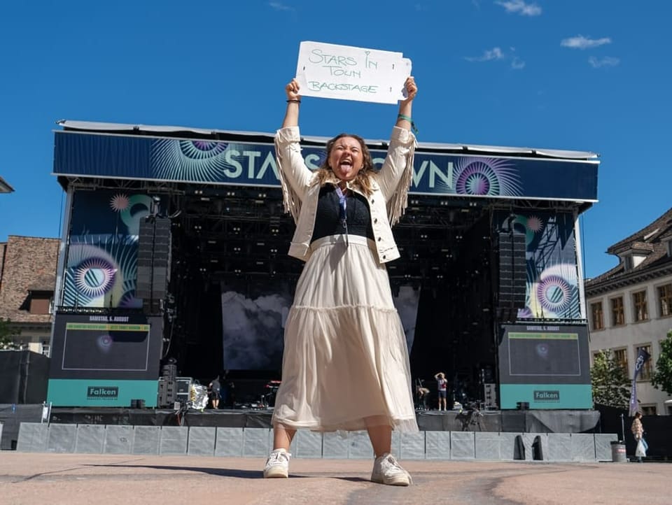 Joya Marleen hält ein Schild in die Höhe wo steht: Stars in Town Backstage