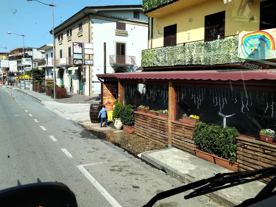 Menschenleere Strasse mit geschlossenen Läden und Bars in Italien.