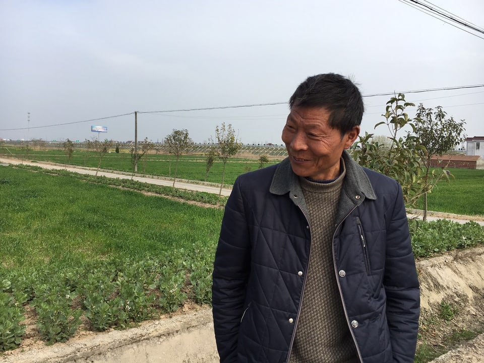 Bauer Hu Chenghai, im Hintergrund sein Land.