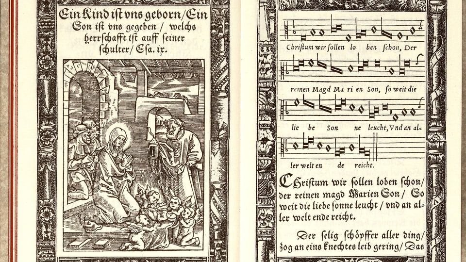 Aufgeschlagenes Gesangbuch: rechte Seite ein Bild einer Frau und eines Mannes mit Baby, linke Seite Noten mit Text.