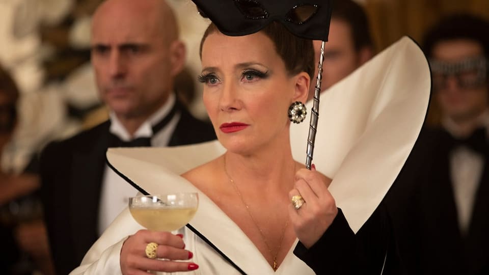 Frau in extravagantem Kleid mit einem Cocktailglas