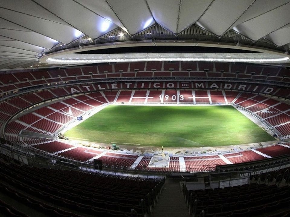 Blick auf das Stadioninnere mit leerer Tribüne und Rasen.
