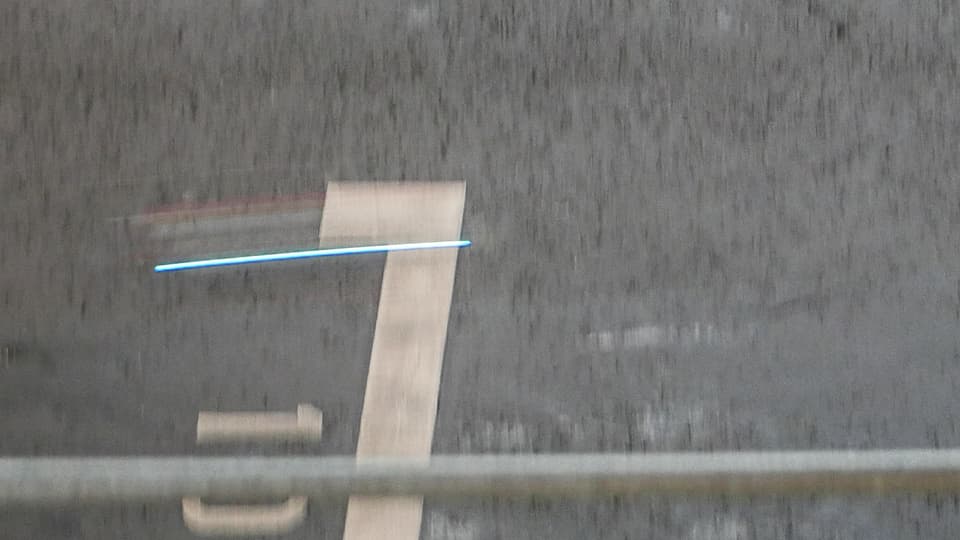 Ein hellblauer Strich über Asphalt: Ein Renn-Quadrokopter auf High-speed.