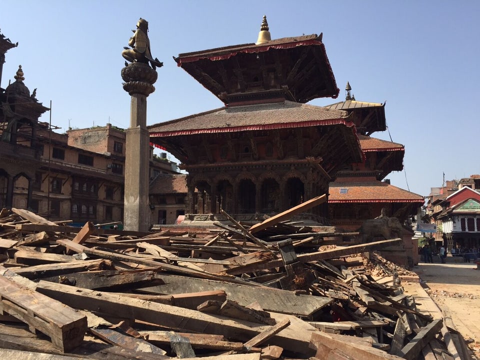 Durbar Platz in Kathmandu, im Vordergrund liegen Überreste des kaputten Holz-Tempels.