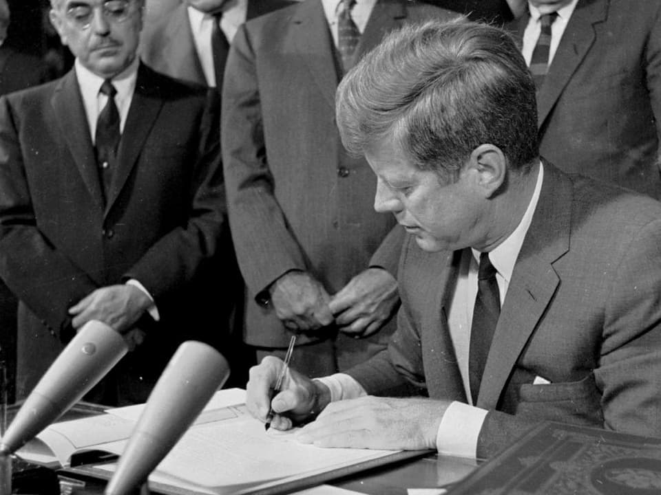 Kennedy unterschreibt eine Depesche.