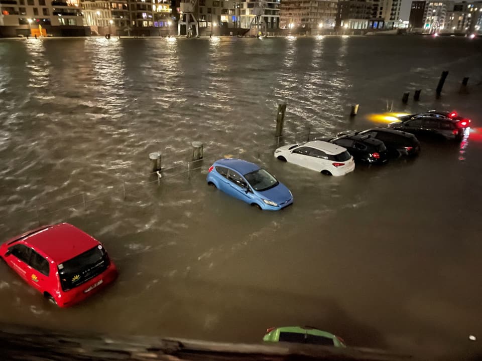 Autos schwimmen wegen dem Hochwasser im Wasser. 