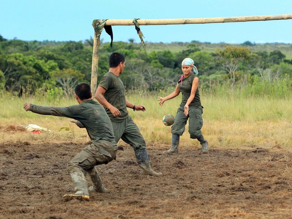 Drei Freiheitskämpfer spielen im Dschungel Fussball.