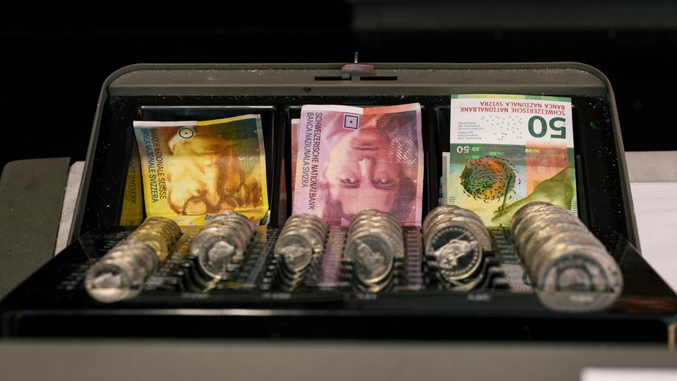 Kasse mit Schweizer Noten und Münzen