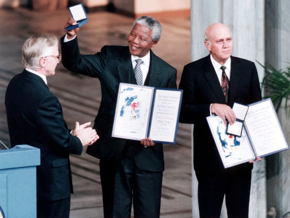 Nelson Mandela und Frederik Willem de Klerk präsentieren die Medallien und Zertifikate nach der Verleihung des Friedensnobelpreises.