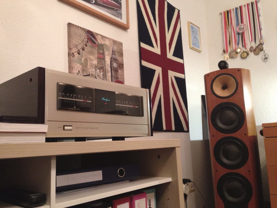 Radio im Wohnzimmer, mit Medaillen und einer Englandflagge an der Wand.