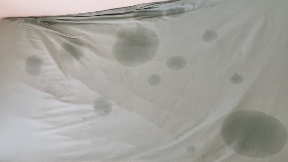 Eine Matratze mit sichtbaren Wasserflecken.