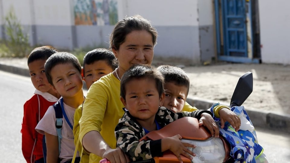 Uigurische Frau mit Kindern in der chinesischen Region Xinjiang.