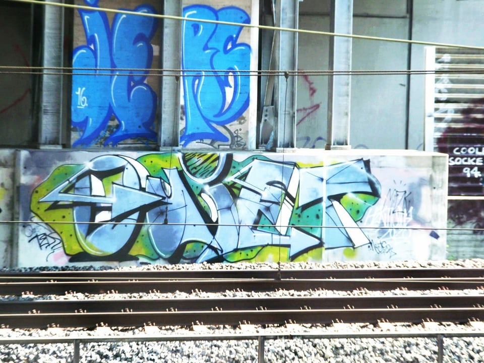 Graffiti-Schriftzug «Quiet» an einem Bahngeleis.