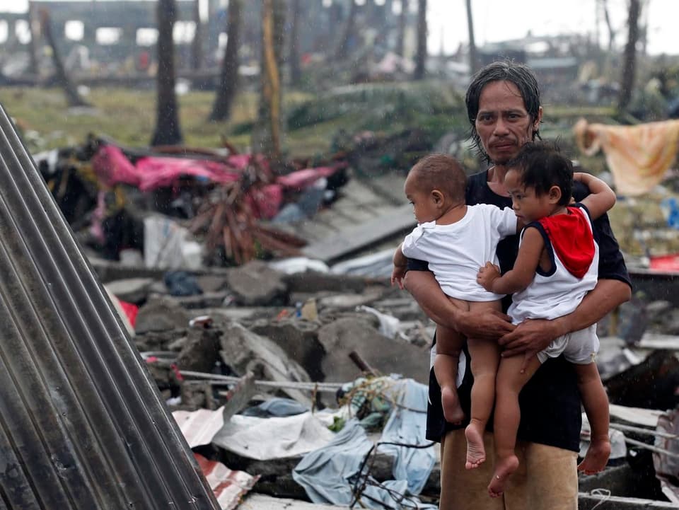 Ein Vater mit seinen zwei Kindern in Tacloban.