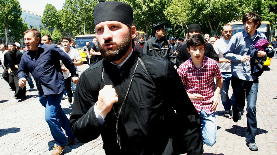 Georgisch-Orthodoxe Priester und Demonstranten gehen gewaltsam gegen Menschenrechtsaktivisten vor. 