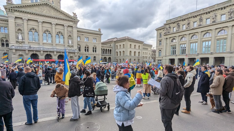 Viele Menschen und ukrainische Flaggen auf dem Bundesplatz in Bern.