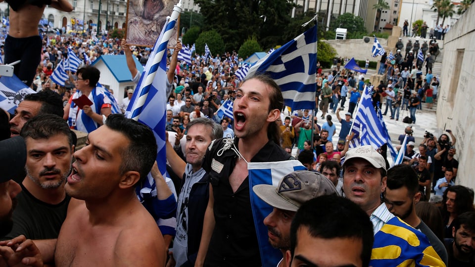 Demonstranten mit griechischen Flaggen