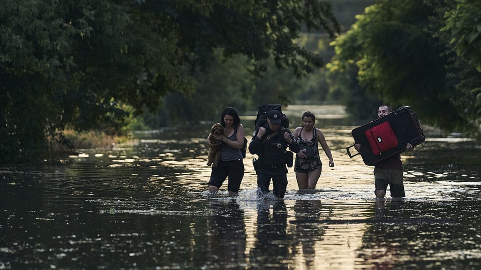 Die Evakuierung des Katastrophengebiets, hier ein Bild aus der Region um Cherson, läuft. Menschen waten durch Wasser.