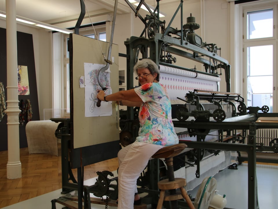 Eine Mitarbeiterin des Textilmuseums in St. Gallen stickt an einer Handstickmaschine.