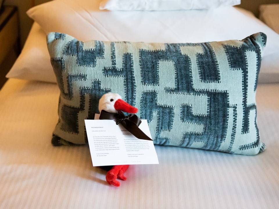 5-Sterne-Service Storchen-Stofftier auf dem Bett
