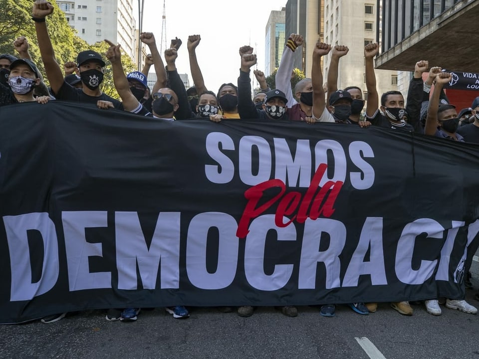 Demonstranten mit einem Banner für die Demokratie.