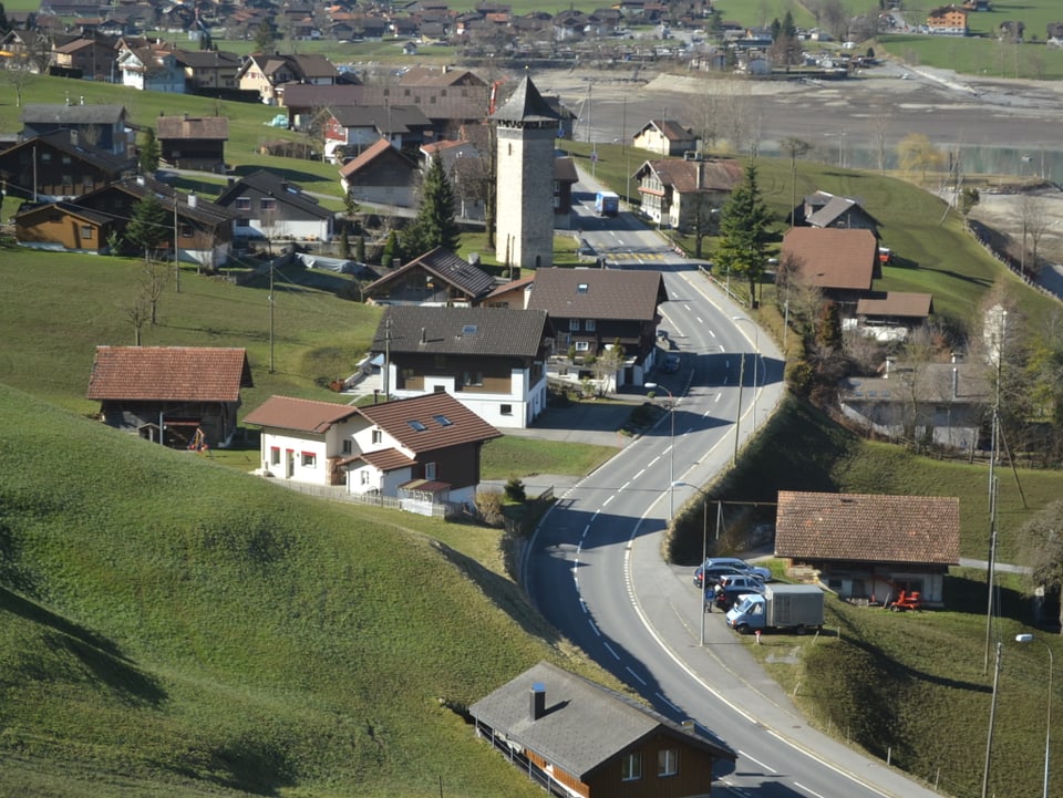 Blick vom erhöhten Zuggeleise über das Dorf mit dem Turm in der MItte.